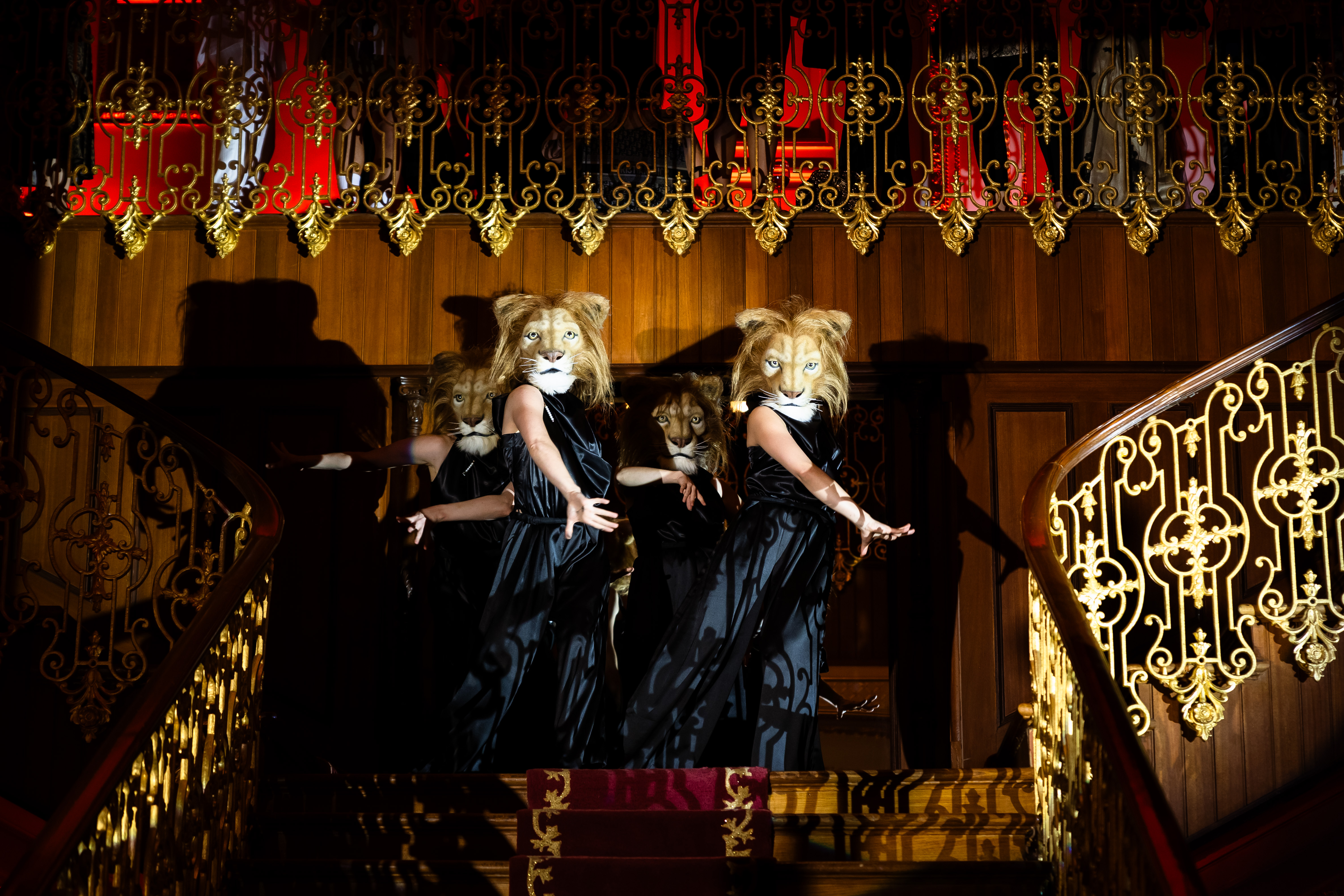 Lion-masked performers descending ornate staircase
