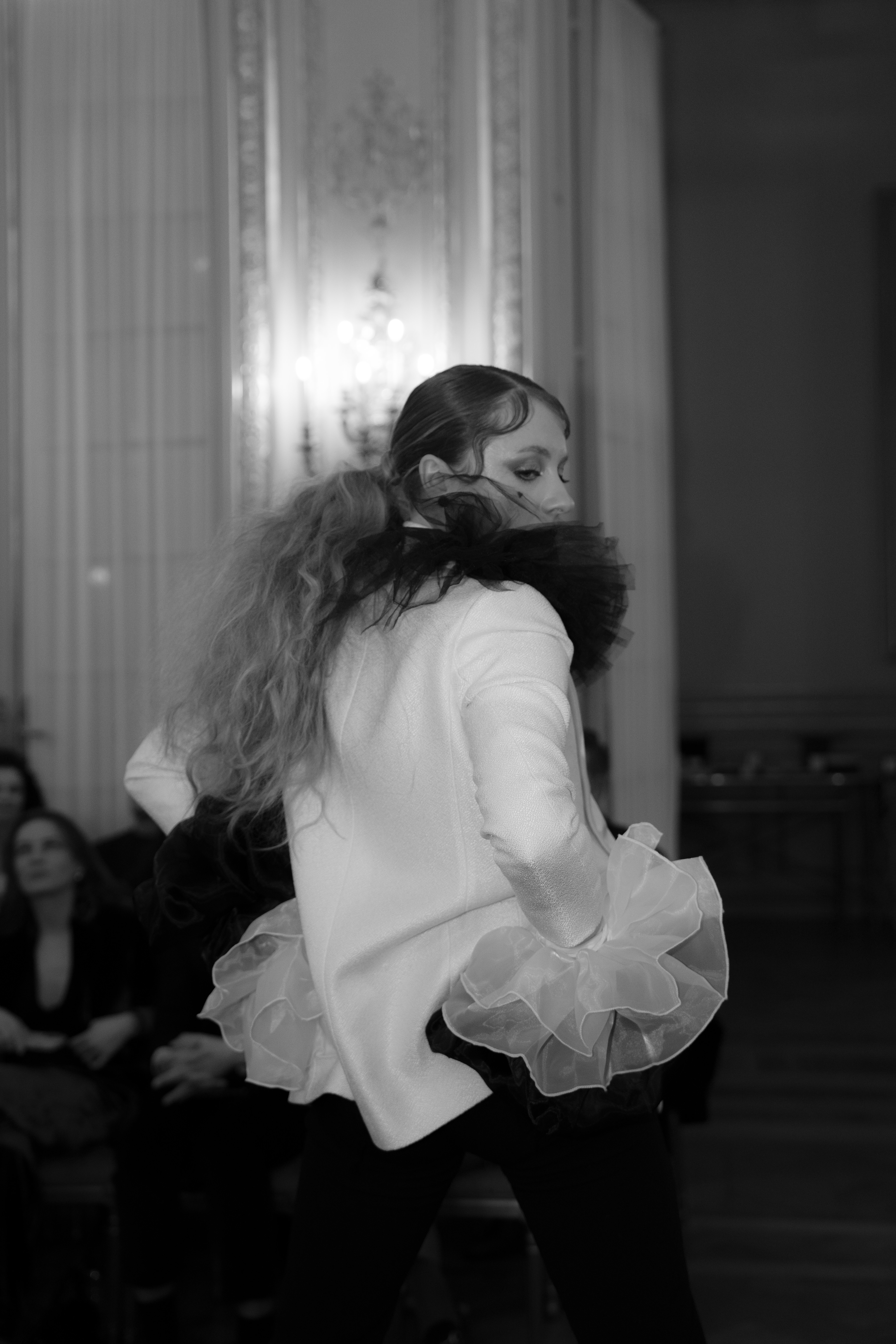 Dancer turning with ruffle sleeve in ballroom